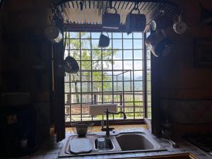 a kitchen with a sink and a large window at La Maggiorana in Tagliacozzo