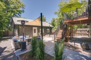 a house with a patio and a balcony with an umbrella at Old Town Carriage House with Private Patio in Fort Collins