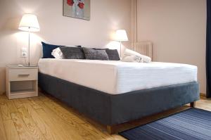 - un grand lit dans une chambre dotée d'un tapis bleu dans l'établissement Homey Comfort Apartments, à Athènes