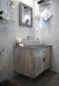 La salle de bains est pourvue d'un lavabo et d'un miroir. dans l'établissement Homey Comfort Apartments, à Athènes
