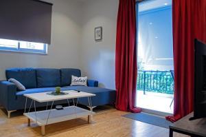 a living room with a blue couch and red curtains at Homey Comfort Apartments in Athens