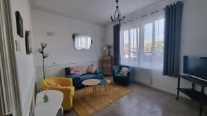 een woonkamer met een blauwe bank en een tv bij Maison du quai à Saint Valéry sur Somme in Saint-Valery-sur-Somme