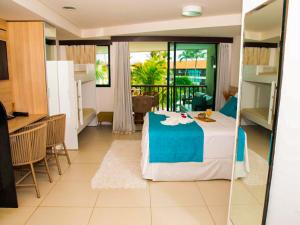 Zimmer mit einem Bett, einer Küche und einem Tisch in der Unterkunft Porto Beach Resort - Marulhos in Porto De Galinhas