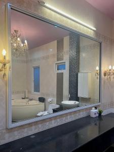 espejo grande en el baño con bañera y lavabo en Keang Khuen Pool Villa Pran เคียงคลื่น พูลวิลล่า ปราณ, en Ban Nong Ban Kao