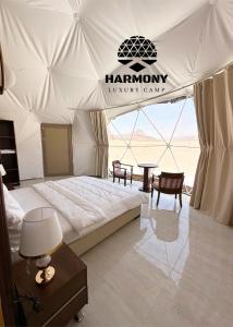 a bedroom in a tent with a bed and a table at Harmony Luxury Camp in Wadi Rum