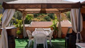 a table and chairs under a gazebo at Like Home Apartment in Reggio Calabria