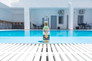 Eine Flasche Bier steht auf einem Tisch neben einem Swimmingpool. in der Unterkunft Dodomar Selections in Perissa + 49 Fotos