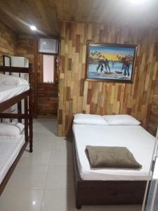 a room with two beds and a painting on the wall at Casa 600mt da praia, 6km do Beto Carrero in Navegantes