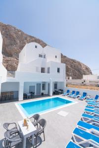 a villa with a swimming pool and blue chairs at Dodomar Selection in Perissa