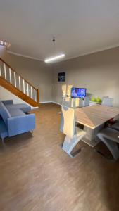 a living room with a wooden table and blue chairs at Varandas de Troia in Troia