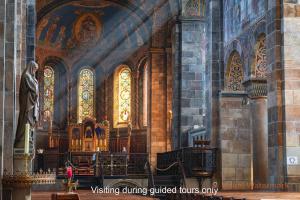 a church with a statue and stained glass windows at Abdij Hotel Rolduc in Kerkrade