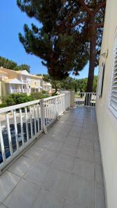 a balcony with a white fence and a tree at Varandas de Troia in Troia