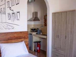 a bedroom with a bed and a kitchen at DIPOLIS luxury apartments Syros in Episkopíon