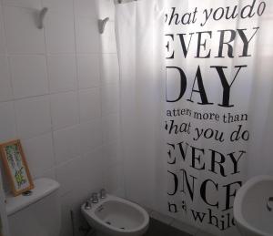 a bathroom with a shower curtain that says every day at La Casa de Ischia in Mar del Plata +9 photos