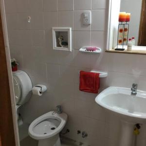 a bathroom with a white toilet and a sink at Casa en Los Reyunos, Ubicación perfecta Frente al lago in San Rafael +13 photos