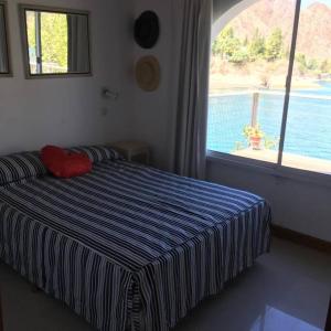 a bedroom with a bed with a view of the water at Casa en Los Reyunos, Ubicación perfecta Frente al lago in San Rafael