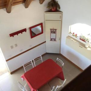 cocina con mesa roja, sillas y nevera en Casa en Los Reyunos, Ubicación perfecta Frente al lago en San Rafael
