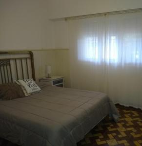 a bedroom with a bed with a pillow and a window at La Casa de Ischia in Mar del Plata