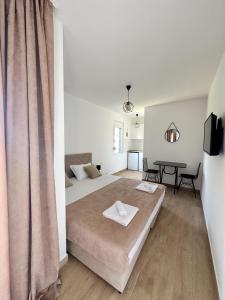 a white bedroom with a bed and a table at Danin apartmani in Bar