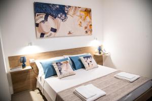 a bedroom with a large bed with blue pillows at Granelli di sabbia in Porto Cesareo