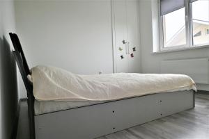 Cama en habitación blanca con ventana en Bright and cozy apartment nr. 1, en Chişinău