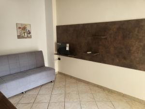 ein Wohnzimmer mit einem Sofa und einer Wand in der Unterkunft San Silvestro House in Cariati