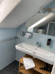 ein Badezimmer mit einem weißen Waschbecken und einem Spiegel in der Unterkunft Haus Kleinbichler in Faak am See