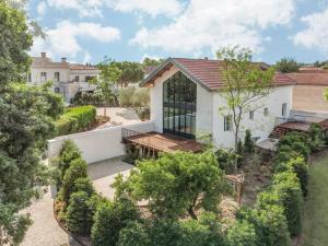 - une vue sur une maison blanche avec des arbres dans l'établissement La Nauve, Hôtel & Jardin - Relais & Châteaux, à Cognac
