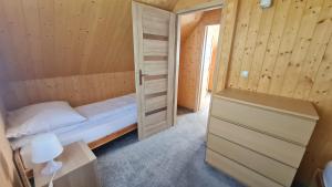 コパリノにあるDomki na Żytniejのベッド1台とクローゼットが備わる小さな客室です。