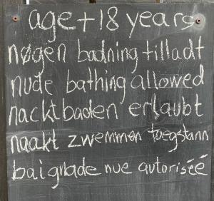 un cartel de pizarra con escrito en él en Farm61 badehotellet i det midtjydske - alder +18 år, en Tjele