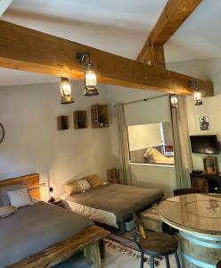 sypialnia z 2 łóżkami, stołem i lustrem w obiekcie Logement atypique - Chevaux Miniatures Rhéa Horses w mieście Bargemon