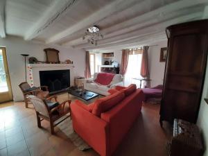 a living room with a red couch and a fireplace at La Maison d'Albert et Julia à 12 mn du Futuroscope in Beaumont