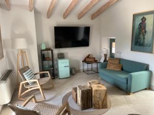 a living room with a blue couch and a tv at HOTEL CA'N UETAM in Valldemossa