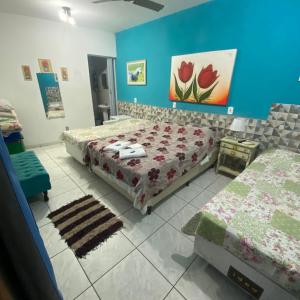 a bedroom with two beds and a blue wall at Pousada Chuá Chuá in Conservatória