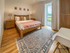 een slaapkamer met een bed, een raam en een tapijt bij Yew Tree Barn - Hw7737 in Usk