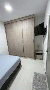 a bedroom with a bed and a tv in it at Apartamento muy cerca al Mar!-0k in Cartagena de Indias