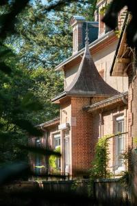 a brick building with a tower on top of it at Manoir d'Egrefin in Saint-Martin-dʼAbbat