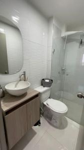 a bathroom with a sink and a toilet and a mirror at Apartamento muy cerca al Mar!-0k in Cartagena de Indias