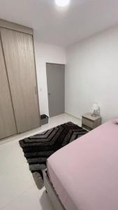 a white bedroom with a bed and a mirror at Apartamento muy cerca al Mar!-0k in Cartagena de Indias