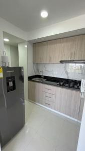 a kitchen with a stainless steel refrigerator and a sink at Apartamento muy cerca al Mar!-0k in Cartagena de Indias