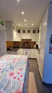 eine Küche mit weißen Schränken und einem Bett mit Blumenmuster in der Unterkunft Maison du quai à Saint Valéry sur Somme in Saint-Valery-sur-Somme + 32 Fotos