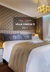 a bedroom with a bed with a sign on the wall at The Queen Luxury Apartments - Villa Vinicia in Luxembourg