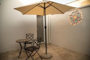a table and chair with an umbrella in a room at Granelli di sabbia in Porto Cesareo