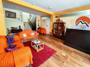 a living room with an orange couch and a stage at SUMAQ PUNO in Puno