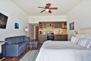 a bedroom with a bed and a blue couch at Waiakea Villas 4329 condo in Hilo