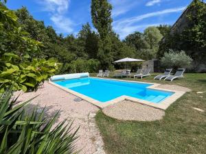 una piscina in un cortile con sedie e tavolo di Les gîtes de La Pellerie - 2 piscines & spa Jacuzzi - Touraine - 3 gîtes - familial, calme, campagne a Saint-Branchs