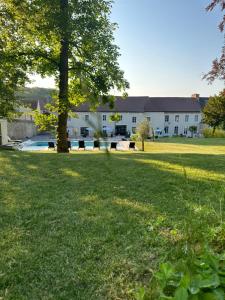 a large grass field with a building in the background at Le Domaine Des Sources in Saint-Martin-dʼAblois