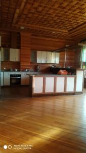 eine große Küche mit weißen Schränken und Holzböden in der Unterkunft Astara Paradise Villa in Astara