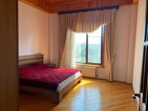 1 dormitorio con cama roja y ventana en Astara Paradise Villa en Astara