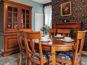 uma sala de jantar com uma mesa de madeira e cadeiras em Orchard House em Langrigg